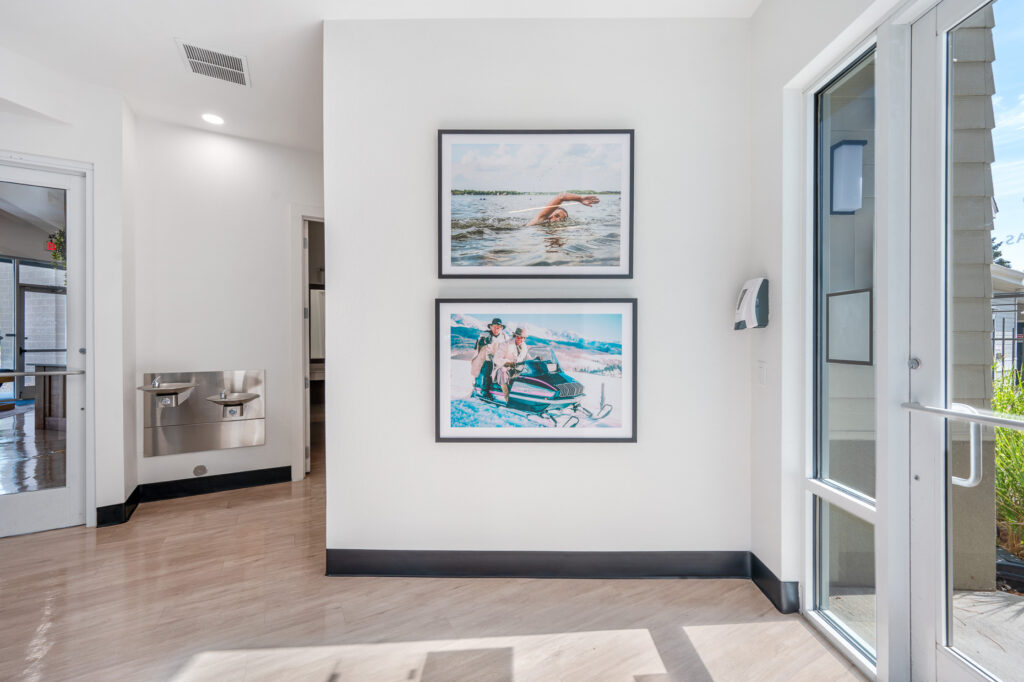 Fitness center entrance space with water fountains and outdoor activity pictures on the wall